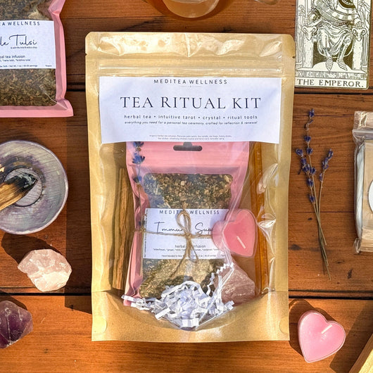 Tea Ritual Kit with tea, packaging, and tarot cards on a wooden surface